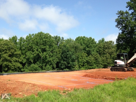 Freshly cleared homebuilding site with excavator and operator