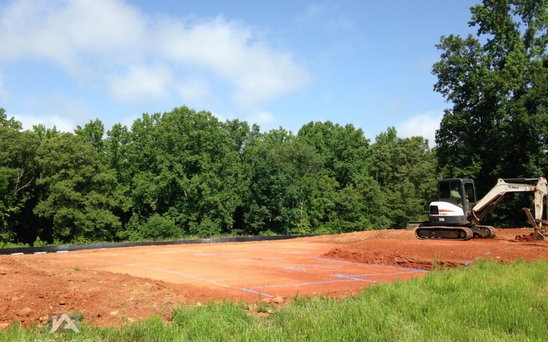 Freshly cleared homebuilding site with excavator and operator